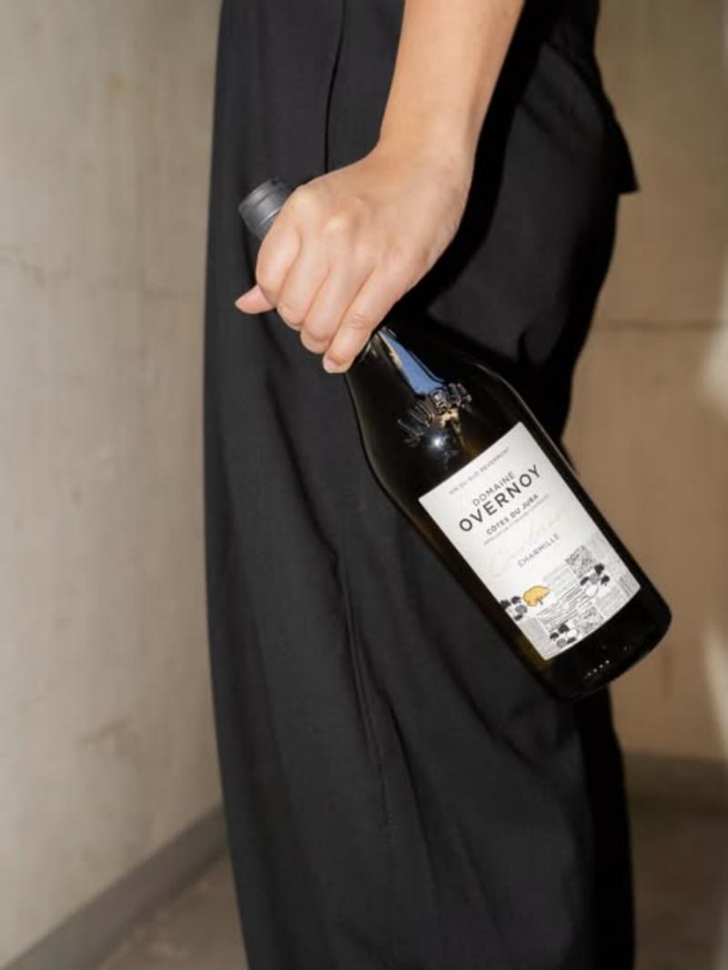 Someone carrying a bottle of Overnoy under their arm
